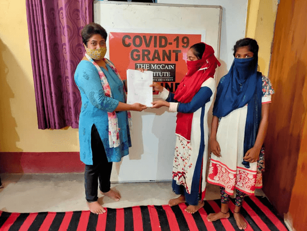 sahana mishra celebrating receipt of covid-19 grant with several women